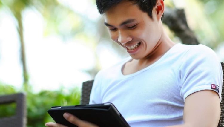 Student smiling using iPad