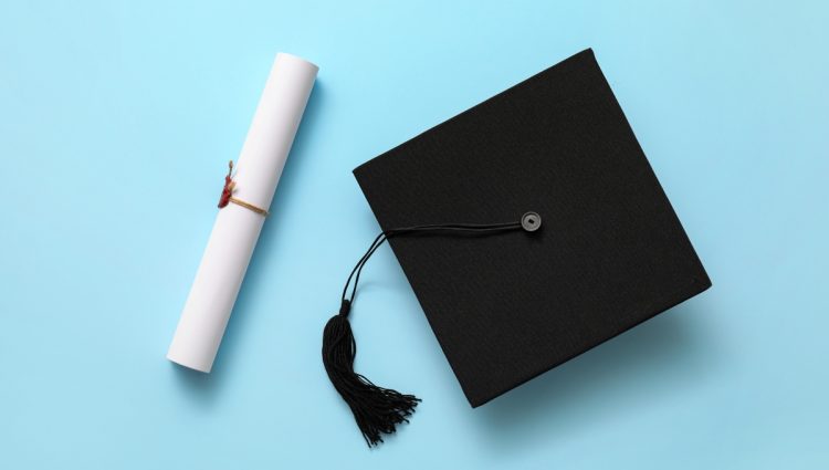 A graduation hat and a diploma on a blue background