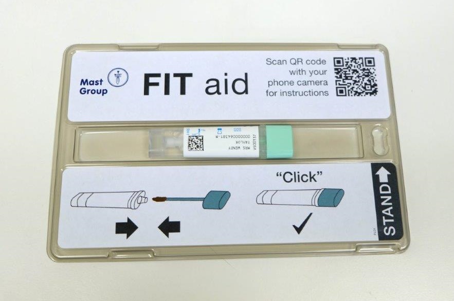 Image shows open FIT aid kit. The bottle and dip stick are closed and are lying down in the specially designed channel in the centre of the box.