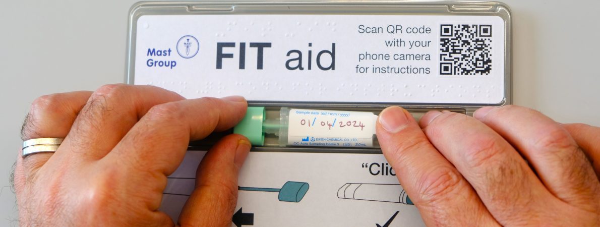 A pair of hands closing a FIT (Faecal Immunochemical Test) bottle with braille on the FIT aid tool. The hands slide the stick and tube down the accessible channel.