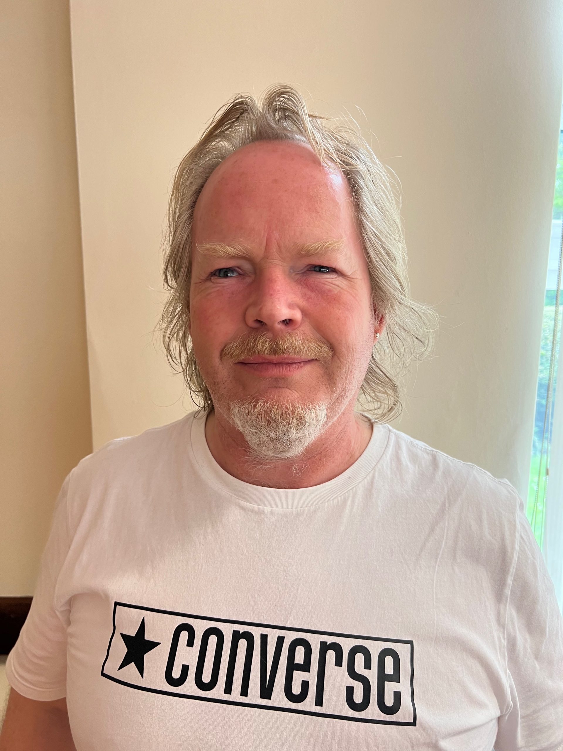 headshot of Steve smiling at camera. He is wearing a white t-shirt with the words ‘converse’ on it – so may not want to use as branded.